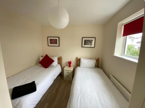 two twin beds in a room with a window at Isle of Anglesey Spacious Home in Llanfairpwllgwyngyll