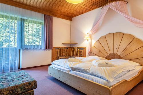 a bedroom with a large bed and a large window at Ferienparadies Sabina Piz in Alpe di Siusi