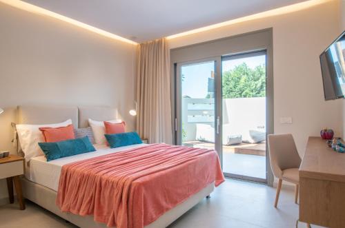 a bedroom with a large bed and a balcony at Grande Mandi & Jani Villa in Laganas