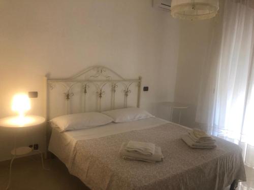 ein Schlafzimmer mit einem weißen Bett mit zwei Handtüchern darauf in der Unterkunft Il Cuore di Napoli in Neapel