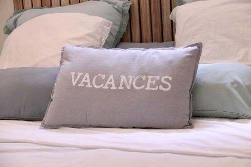 a pillow with the word vengeance written on it on a bed at Chambre d'hôtes Les terrasses de Saint Clair in Sète