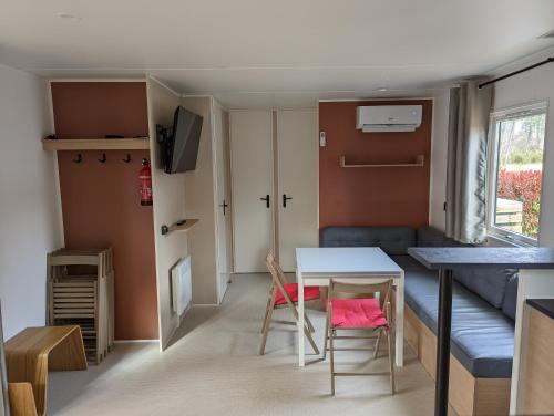 a small room with a table and chairs and a couch at Logement LUXE de 44m2 Les pieds dans l'eau Ménage et draps inclus Camping 5 Etoiles Lac Biscarrosse Koyobalys in Biscarrosse