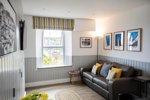 a living room with a couch and a window at Seafarers - Coastguard Cottage with sea views, garden and parking in Mevagissey