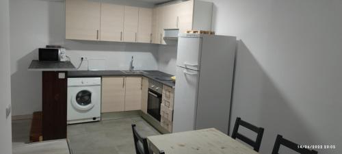 a kitchen with a white refrigerator and a table and chairs at Hotelet de Betlan in Betlán