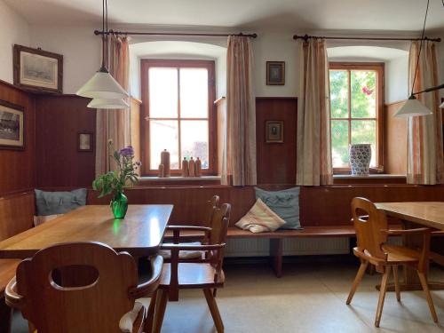 een eetkamer met een tafel en stoelen en een raam bij Gasthaus zum Schwan in Castell
