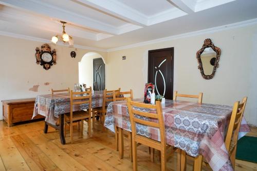 a dining room with tables and chairs and a mirror at Guesthouse Nora in Ushguli