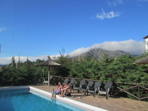 two women sitting on chairs next to a swimming pool at Pa-kuas del Uritorco in Capilla del Monte
