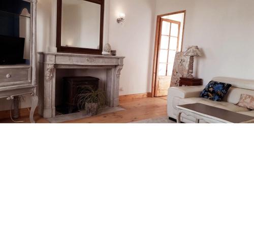 ein Wohnzimmer mit einem Kamin und einer weißen Couch in der Unterkunft Manoir Demouret Sarlat in Sarlat-la-Canéda