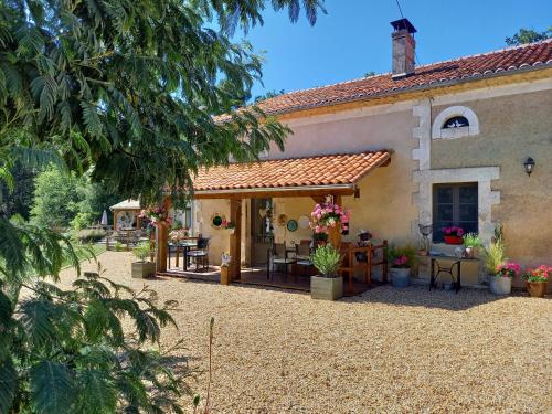 an exterior view of a house with a patio at La Maison Verte in Siorac-de-Ribérac