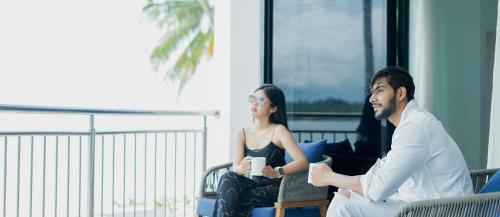 een man en een vrouw zitten in een kamer bij Nasara Resort Mentawai in Tua Pejat