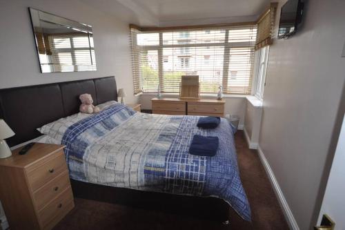 Un dormitorio con una cama con un osito de peluche. en Vista Apartments, Goodrington Beach, Paignton, en Paignton