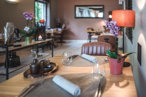 a table with plates and napkins on top of it at Hotel Au Coeur de Lacuisine in Florenville