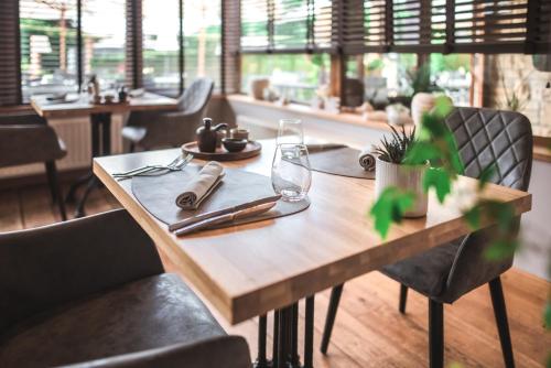 a wooden table with a napkin and glasses on it at Hotel Au Coeur de Lacuisine in Florenville
