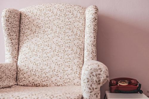 a watch sitting on top of a white chair at Hotel Casa Camilla in Verbania