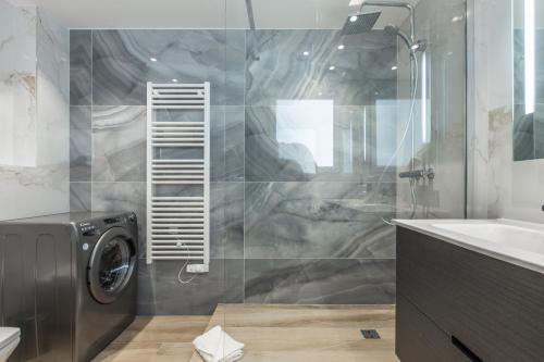 un bagno con lavatrice e lavandino di Résidence Topaze - Central - Luxurious - 50m Croisette Palais - LRA CANNES a Cannes
