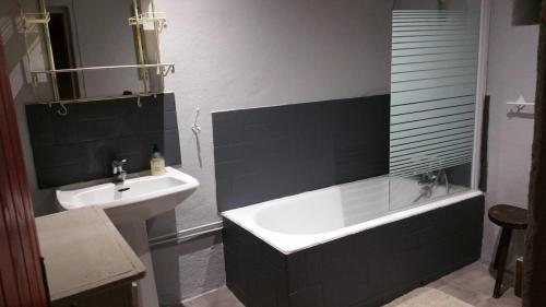 a bathroom with a bath tub and a sink at Coeur d'Aubrac in Recoules-dʼAubrac