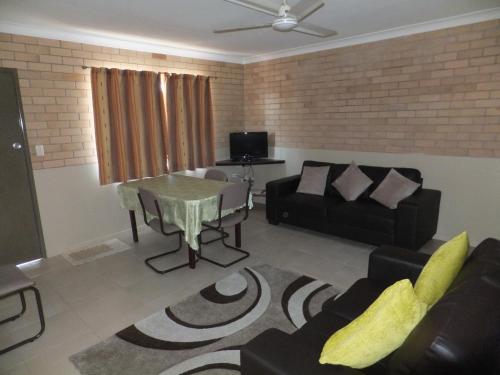 a living room filled with furniture and a tv at Sunrise Units in Hervey Bay