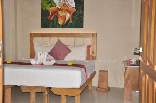 a bedroom with a bed with two stuffed animals on it at Crystal Beach Bali in Candidasa