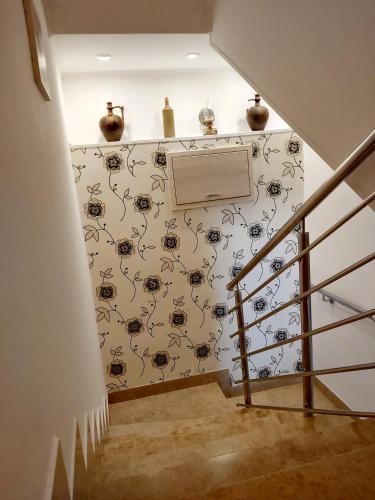 a hallway with a staircase with a spider wallpaper at Meduza B&b in Barbat na Rabu