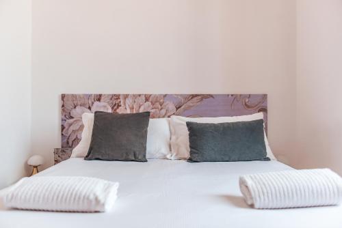 a bedroom with a white bed with two pillows at Hotel Casa Camilla in Verbania