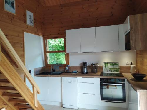 a kitchen with white appliances in a wooden cabin at Le Carré de Bois in Briançon