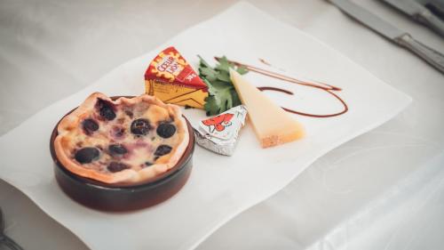 a dessert with blueberries and cheese on a white table at Logis Hôtel Vuillot in Cuiseaux