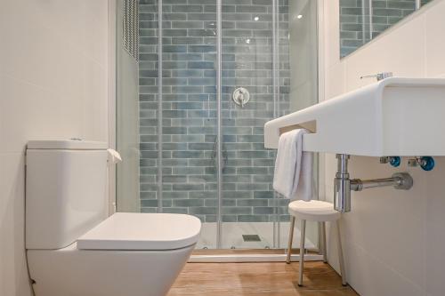 a bathroom with a toilet and a sink and a shower at Hotel Pinos Playa in Cala Santanyi