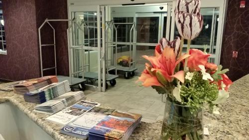 a vase with flowers on a counter in a room at Wingate by Wyndham Elkins in Elkins