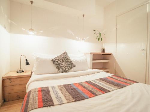 a bedroom with a bed with a striped blanket on it at Alpaca Farm - חוות האלפקות in Mitzpe Ramon