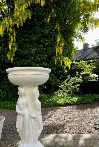 a white statue of a bird bath in a garden at Solhaga Kullahalvön in Jonstorp