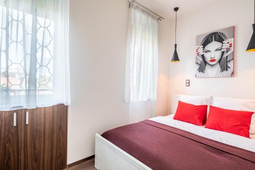 ein Schlafzimmer mit einem Bett mit roten Kissen in der Unterkunft Two bedroom home in Jewish quarter in Budapest