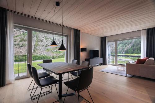 ein Esszimmer mit einem Tisch, Stühlen und einem Sofa in der Unterkunft Andermatt Alpine Apartments in Andermatt