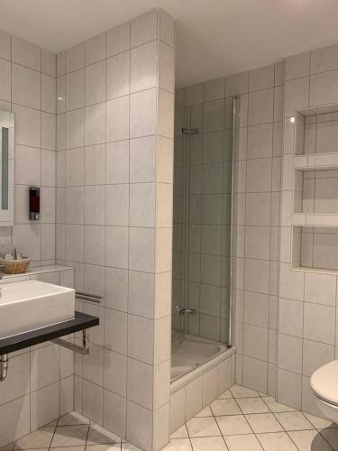 a bathroom with a shower and a sink and a toilet at HGH - Hotel Garni Helbig in Neustadt an der Weinstraße