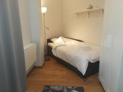 a small bedroom with a bed with white sheets at Pepleri Studio 68 in Tartu