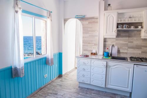 a kitchen with blue and white cabinets and a window at Casa el Mar apartamento El Faro in Güimar
