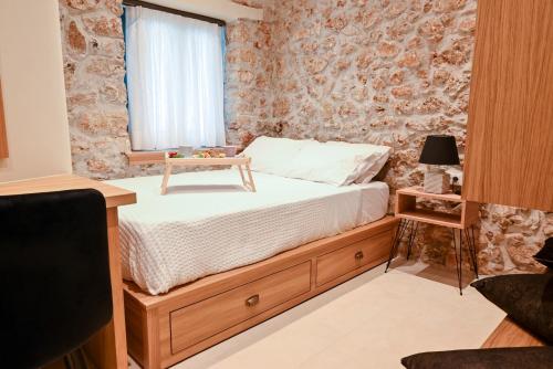 Un dormitorio con una cama con una mesa. en Carpe Diem Moursia Studio, en Liapades