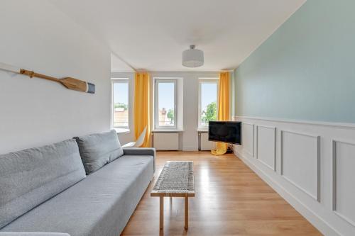 Grand Apartments - Apartament Surfer w centrum Sopotu في سوبوت: غرفة معيشة مع أريكة وتلفزيون