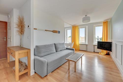 - un salon avec un canapé et une télévision dans l'établissement Grand Apartments - Apartament Surfer w centrum Sopotu, à Sopot