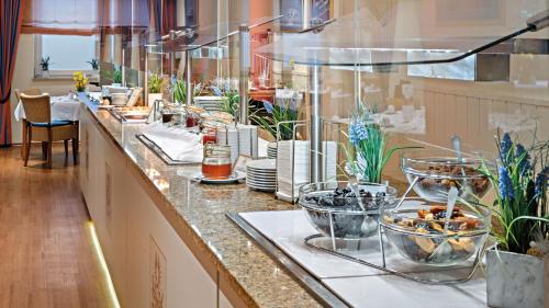 a buffet line with plates and bowls of food at Hotel Juwel in Bad Füssing