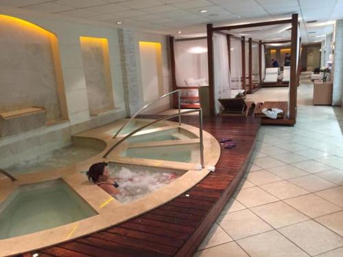 una mujer en una bañera de hidromasaje en una habitación de hotel en Le Parc Residencial Resort en Río de Janeiro