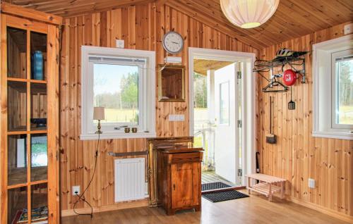 um quarto com paredes de madeira e um relógio na parede em Amazing Home In Lngaryd With Wifi em Långaryd