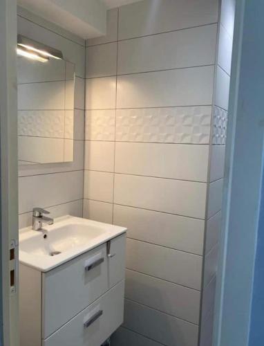 une salle de bain blanche avec un lavabo et un miroir dans l'établissement Superbe appartement Corte, à Corte