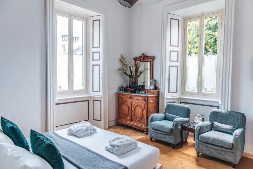 a bedroom with a bed and two chairs and a table at Hotel Casa Camilla in Verbania