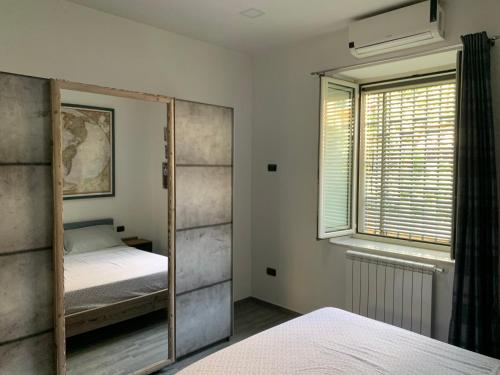 a bedroom with a mirror and a window at Ercolano City Center in Ercolano