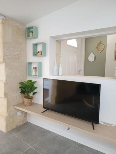 a large flat screen tv sitting in a living room at Immeuble Centre Ville in Saint-Médard-de-Guizières