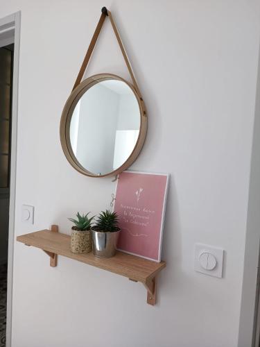 a wooden shelf with a mirror and a sign at Immeuble Centre Ville in Saint-Médard-de-Guizières