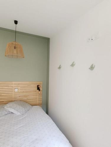 a bedroom with a white bed and a chandelier at Immeuble Centre Ville in Saint-Médard-de-Guizières