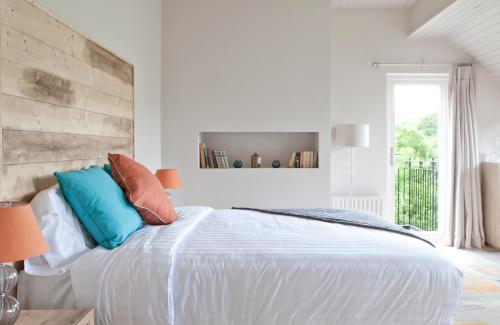 a white bedroom with a large white bed with pillows at Finn Lough in Pettigoe