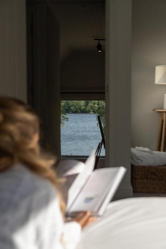 a woman sitting on a bed looking at a laptop at Finn Lough in Pettigoe