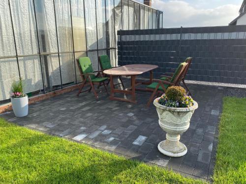 a patio with chairs and a table and a vase with flowers at Ferienwohnung Bouten A in Geldern